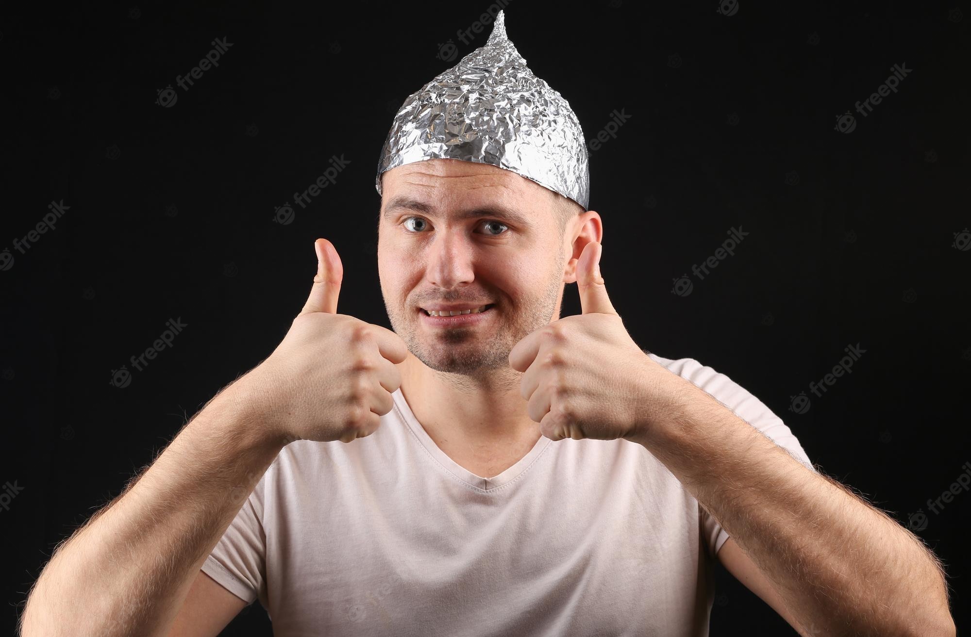 cheerful-bearded-man-foil-hat-smiles-throws-his-thumbs-up-black-background_175682-30843.jpg